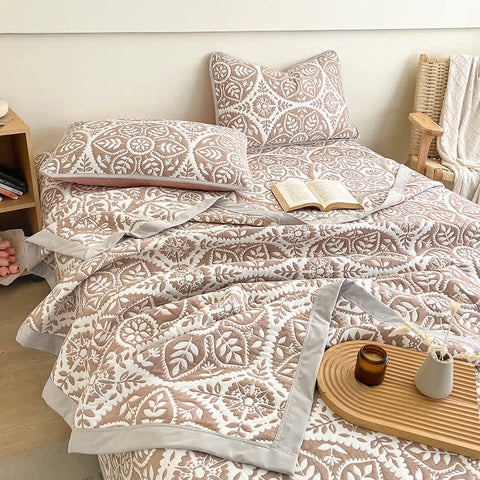 Geometric leaf pattern quilt bedding set in beige with pillows and wooden tray in modern bedroom