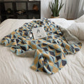 Geometric velvet knit throw blanket on white bed – modern sofa and bed décor