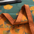 Close-up of Ginkgo Dreams quilt edge showing orange binding and leaf stitching