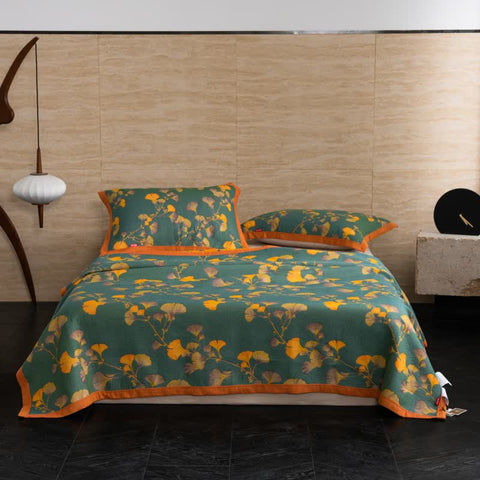 Studio shot of bed dressed in Ginkgo Dreams botanical cotton quilt with matching pillows