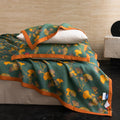 Close-up of Ginkgo Dreams quilt and pillow in botanical green and gold tones