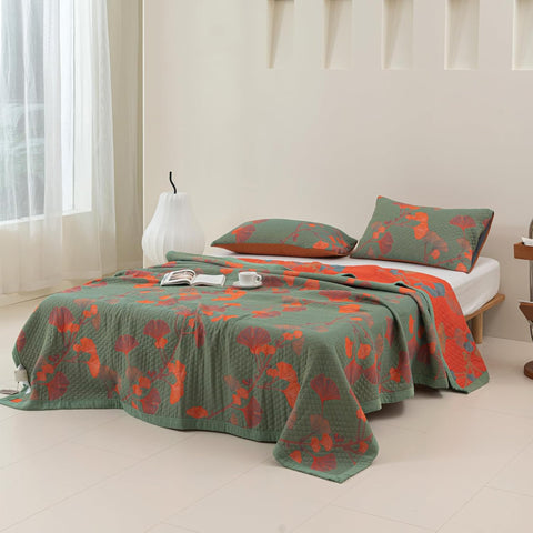 Full view of Ginkgo Leaf Orange Floral Blanket spread on a bed with matching pillowcases in a bright bedroom.