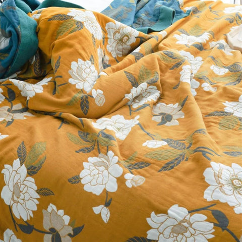 Floral patterned fabric with white flowers on a mustard yellow background