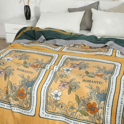 Golden Romance Boho cotton throw blanket draped on bed displaying both sides and cozy bedroom setting.