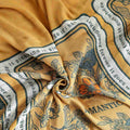 Close-up of a Golden Romance Boho cotton throw blanket yellow fabric with floral and text patterns