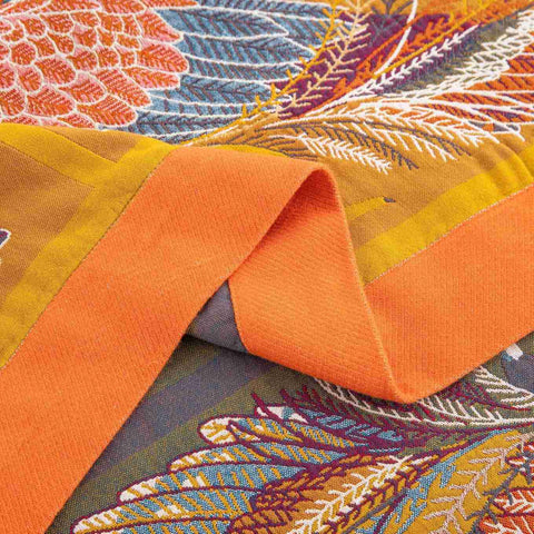 Close-up of a colorful fabric with orange and multicolored patterns and edge