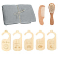 Baby care set with gray cloth, wooden comb, brush, and growth chart markers on a white background.