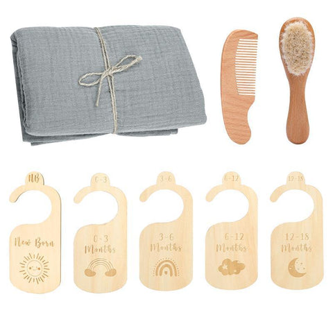Baby care set with gray cloth, wooden comb, brush, and growth chart markers on a white background.