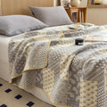 Gray jacquard cotton quilt spread on minimalist bed