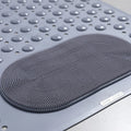 Close-up of foot scrubber texture on gray shower mat

