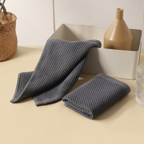 Dark gray microfiber towels displayed with vases on beige table