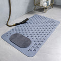 Gray bath mat with textured surface on a bathroom floor, featuring a shower head and brush.