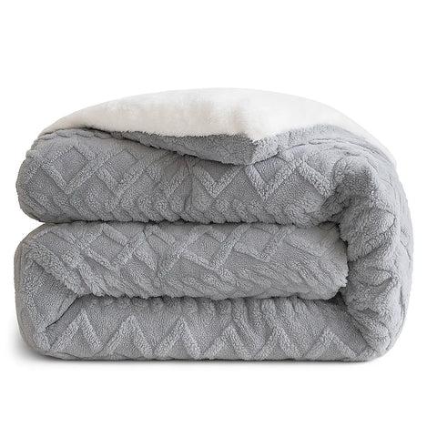 Gray quilt with white sherpa lining on a white background