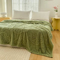 Green butterfly embossed plush throw blanket on minimalist white bed in sunlit room

