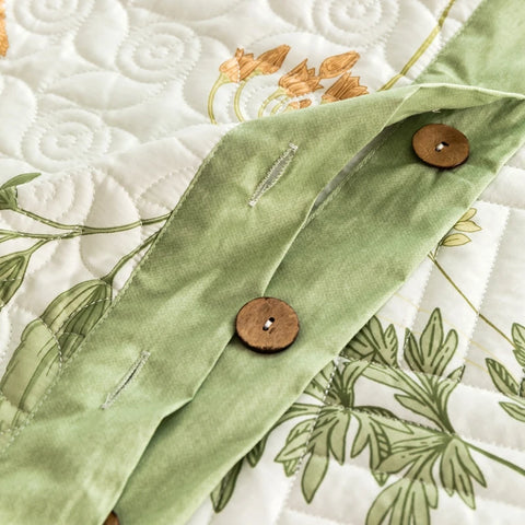Close-up of wooden button closure on green trim botanical quilt