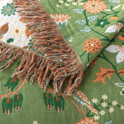 Bed styled with green reversible floral blanket