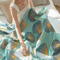 Model showcasing soft green dandelion summer quilt – reversible cotton throw