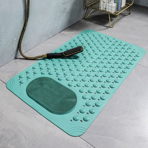 Turquoise bath mat with textured surface on a bathroom floor.