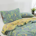 Detail of green and yellow cotton quilt showing reversible floral design