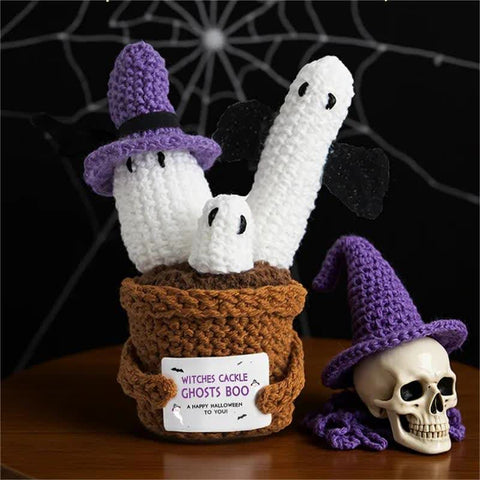 Handmade crochet ghost ornaments in potted plant with festive Halloween decor