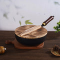 Hammer pattern iron wok pan with wooden lid and handle on wooden board