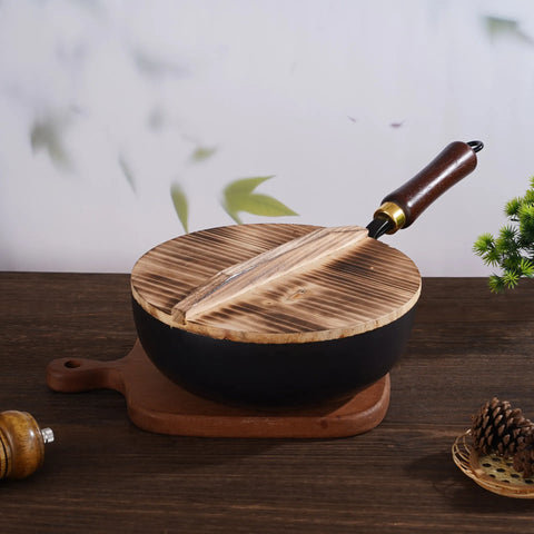 Hammer pattern iron wok pan with wooden lid and handle on wooden board