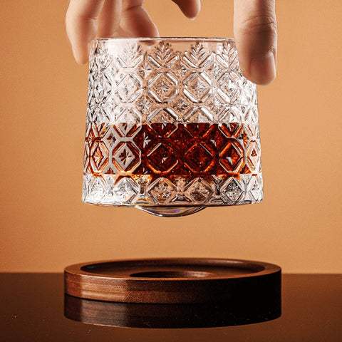 Hand holding vintage whiskey glass with carved crystal pattern