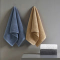 Blue and beige bath towels hanging on wall hooks