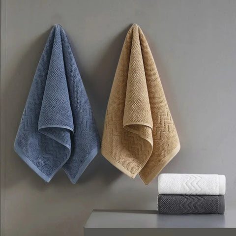 Blue and beige bath towels hanging on wall hooks