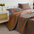 Japanese style cotton quilt on full bed with matching pillows, geometric pattern