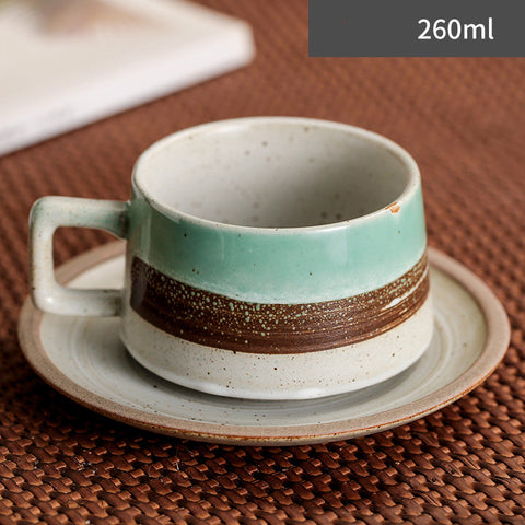 Ceramic cup with a brown stripe on a saucer, placed on a textured surface.