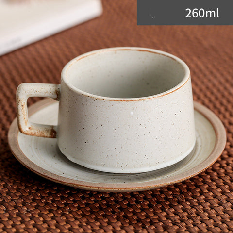 Speckled ceramic cup and saucer set on a woven surface with '260ml' text.