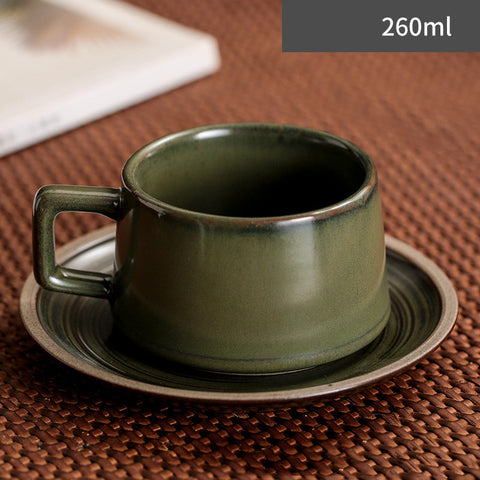 Green ceramic cup with saucer on a brown textured surface, showing capacity of 260ml.