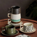 Set of ceramic mugs and saucers on a textured surface with a dark background