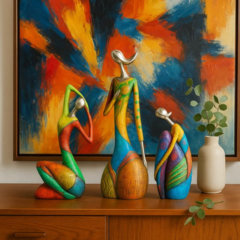 Colorful abstract sculptures on a wooden surface with a vibrant abstract painting in the background.
