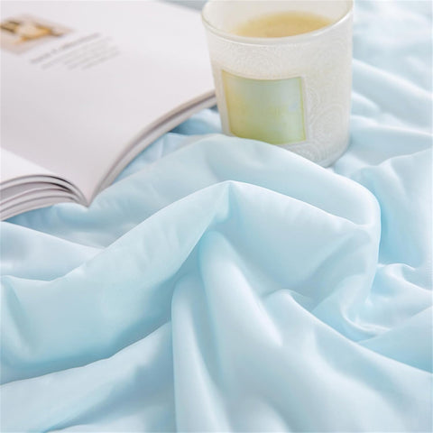 Close-up of soft, smooth light blue ice silk fabric showing delicate texture and silky sheen.