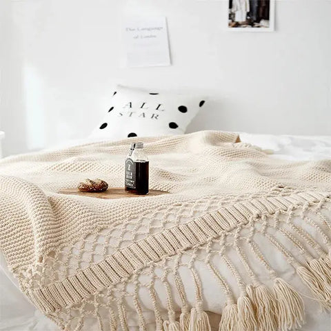 Ivory Cream Handmade Nordic Knit Tassel Blanket on wooden chair – minimalist home décor