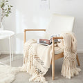 Ivory Cream Handmade Nordic Knit Tassel Blanket on wooden chair – minimalist home décor