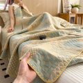 Hand holding soft cotton jacquard summer quilt on bed in warm pastel tones
