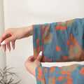 Woman relaxing in blue-orange floral cotton bathrobe
