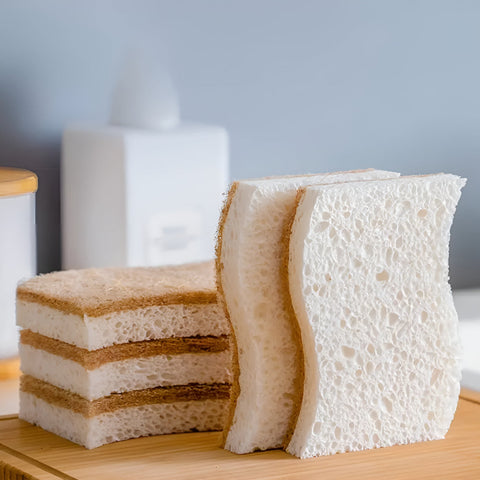 Stack of Kohana coconut fiber sponges on wooden tray