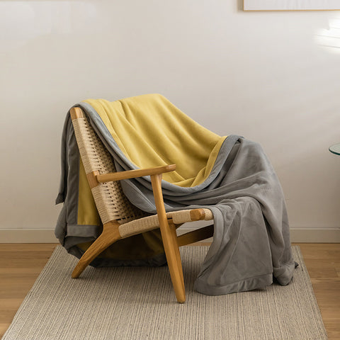 Kumo Harmony Blanket in Yellow Gray draped over chair – Japanese Milk Velvet Tradition
