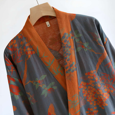 Traditional garment with floral patterns on a hanger against a white background