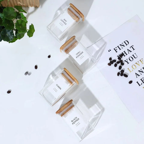 Spice jar set with printed labels shown on wood risers for a clean, styled kitchen look.

