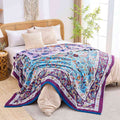 Lavender Meadow Cotton Blanket draped over bed with beige linens and boho-style bedroom decor