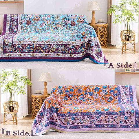 Double-sided Lavender Meadow Cotton Blanket showcasing vibrant floral patterns on both sides draped over sofa in natural light room with bamboo plant and wicker side table