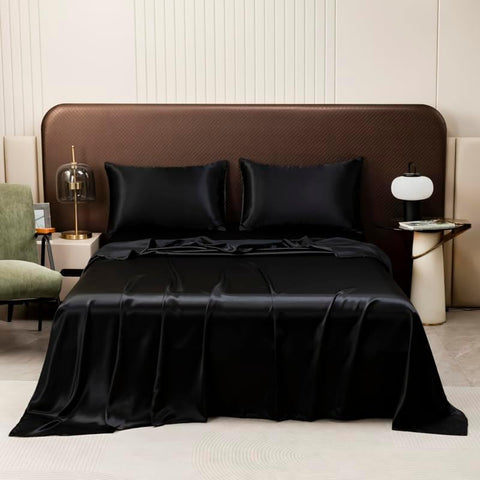Luxury black satin bed sheets and silky pillowcases styled as twin bedding for a modern hotel bedroom look.