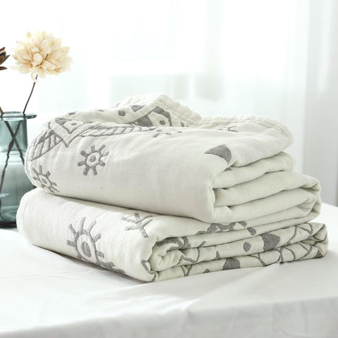 Close-up of folded Malte Beige Cotton Boho Throw Blanket showcasing soft cotton fabric and tribal pattern detail