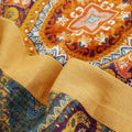 Detail view of mandala pattern on orange cotton quilt with yellow border