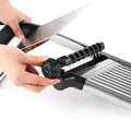 Hand adjusting thickness dial on stainless mandoline slicer
